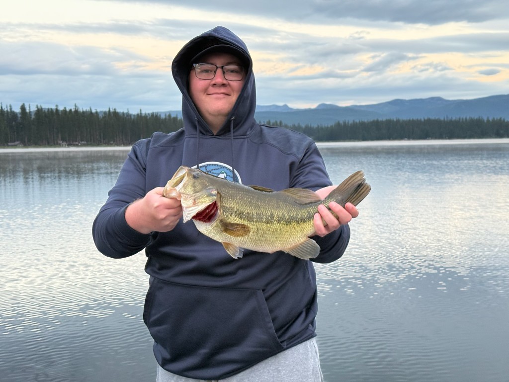 Angler holding a largemouth bass on a lake